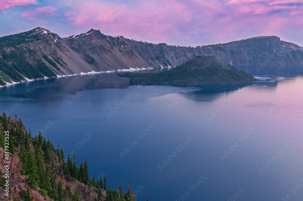 Landscape at dawn of Crater Lake National Park with conifers, Wizard Island, and crater rim, Oregon, USA