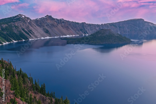 Landscape at dawn of Crater Lake National Park with conifers, Wizard Island, and crater rim, Oregon, USA