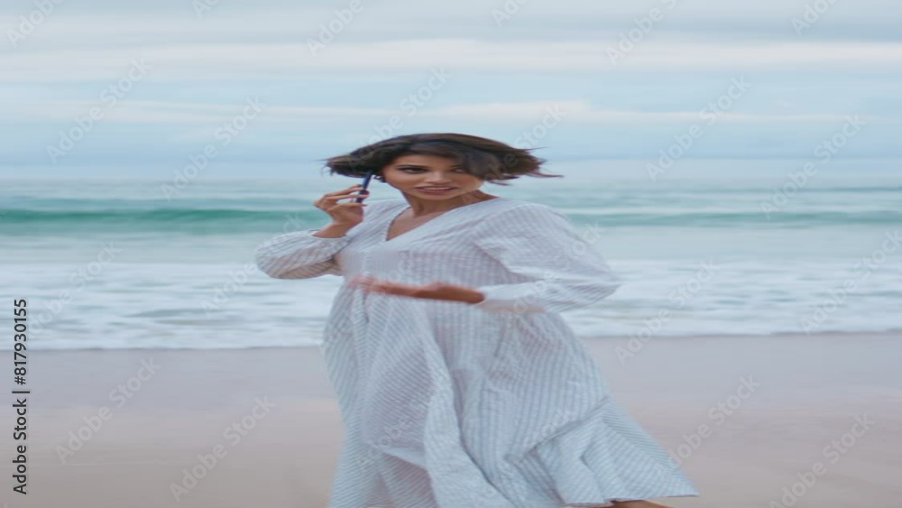 Joyful girl speaking smartphone at ocean shore vertical. Woman walking beach Joyful girl speaking smartphone at ocean shore vertical. Woman walking beach