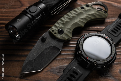 Everyday carry EDC items for men in black color - flashlight, watch and knife. Survival set. Minimal concept