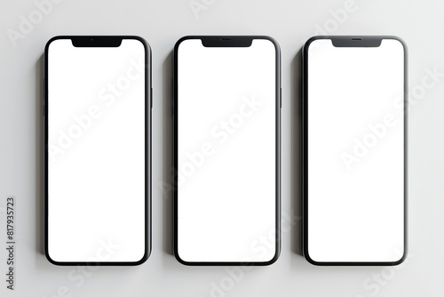 Flat lay of three smartphones with white blank screens mockup on white background. Top view of three smartphones business infographic mockups of web site or design app.