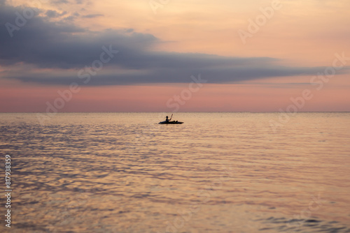 Fototapeta Naklejka Na Ścianę i Meble -  Riding a canoe on the sea during a sunset