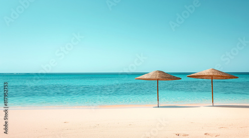 two straw umbrellas on serene tropical beach with turquoise sea and clear sky