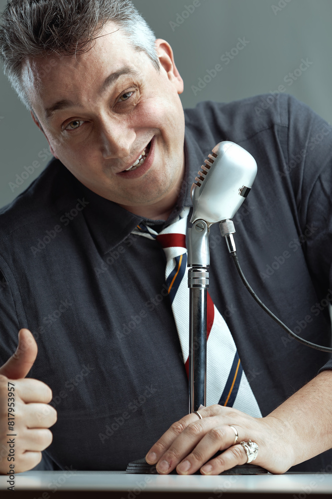 Naklejka premium Man giving thumbs-up, speaking into microphone