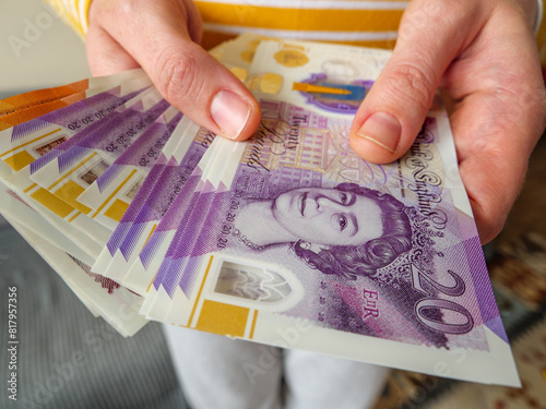 Close up of hands paying out cash money in UK 20 pounds banknotes photo