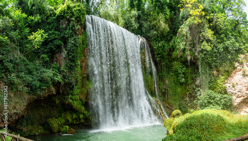 Horizontal panoramic long exposure daytime shot of La Caprichosa  a huge waterfall in a stone monastery in Spain. With the water with silk effect as it falls and lots of green vegetation around