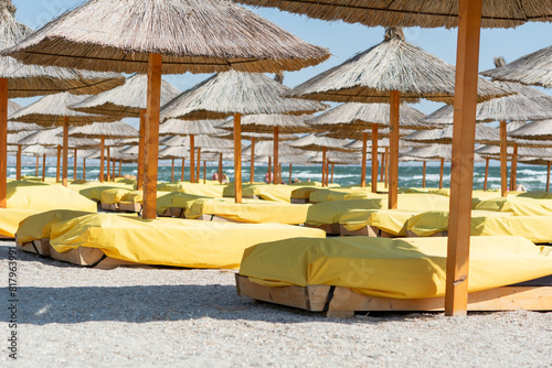 Beach chairs under bamboo beach umbrellas. Shallow depth of field, selective focus.