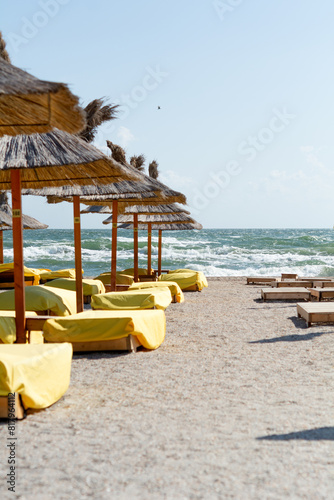 Sea view along the beach chairs. Shallow depth of field, focus on sea waves.