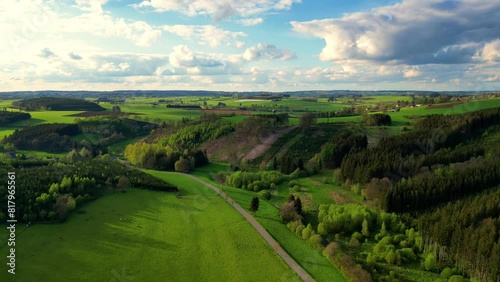 This drone footage offers a stunning overview of the Hautes Fagnes region, showcasing its characteristic rolling hills and extensive forests. The rich greens of the natural landscape under a cloud photo