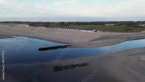 Beautiful flight in summer over the beach in Katwijk aan Zee. People are resting near the sea. Houses for tourists. Beach umbrellas, rides, people swimming in the sea. Beach in Netherland. North Sea. photo