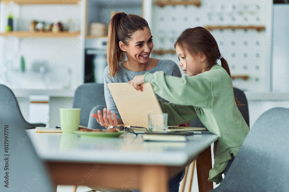 A caring mother encouraging her daughter and helping her study on a wooden laptop A caring mother encouraging her daughter and helping her study on a wooden laptop