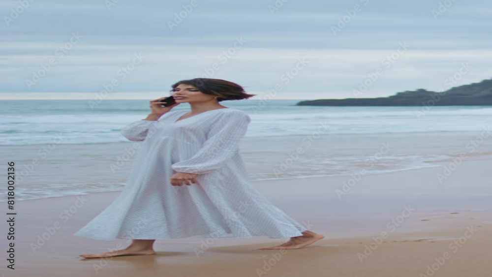 Beautiful woman calling smartphone at ocean beach vertically. Lady walk coast Beautiful woman calling smartphone at ocean beach vertically. Lady walk coast