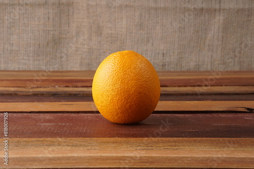 a sunkist orange on a wooden table with studio lighting photo