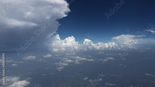 Aerial view of cumulus clouds and a thunderstorm cell from airplane window photo