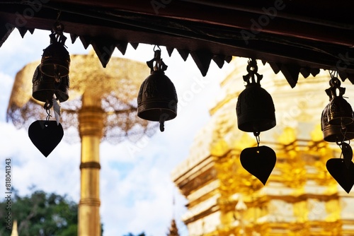 A row of bells hanging from a building. The scene is peaceful and serene