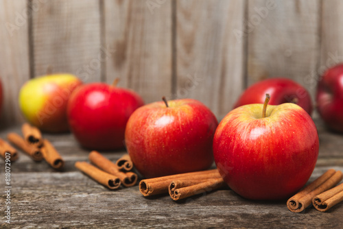 Fototapeta Naklejka Na Ścianę i Meble -  Apples with cinnamon on a textured wooden background. Fragrant red spiced apples with cinnamon sticks and star anise. Apple slices with spicy spices. Place for text. Copy space. Harvesting. Fruits. 