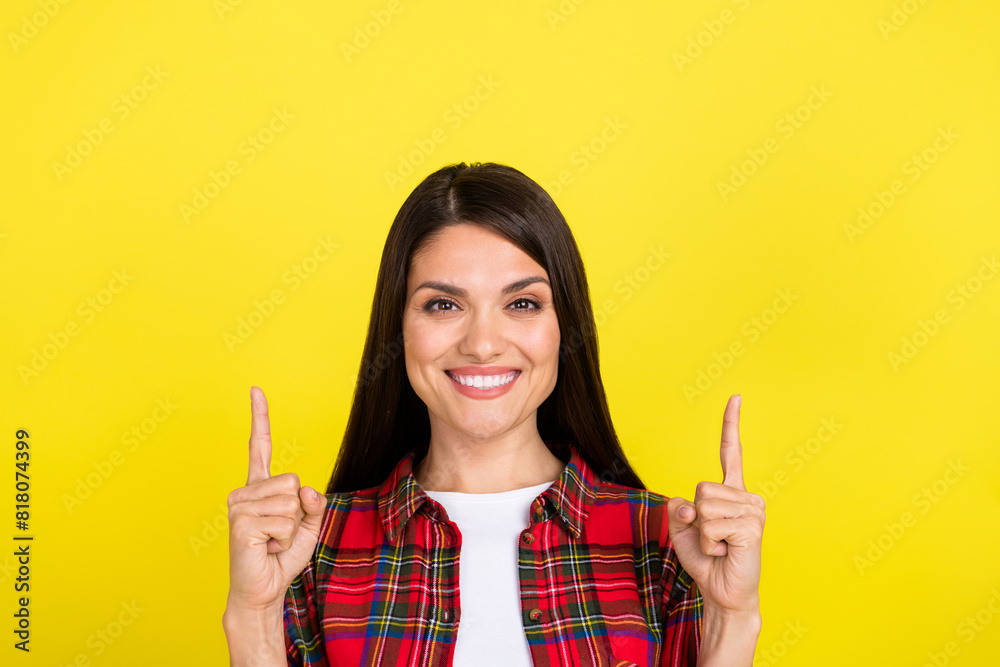 Photo of shiny attractive lady dressed checkered shirt showing two fingers up empty space isolated yellow color background Photo of shiny attractive lady dressed checkered shirt showing two fingers up empty space isolated yellow color background