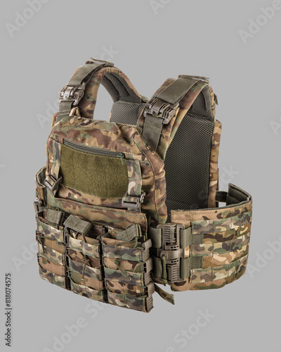 Detailed view of modern camouflage military tactical vest with MOLLE system, multiple pouches, and heavy-duty buckles, isolated on grey background