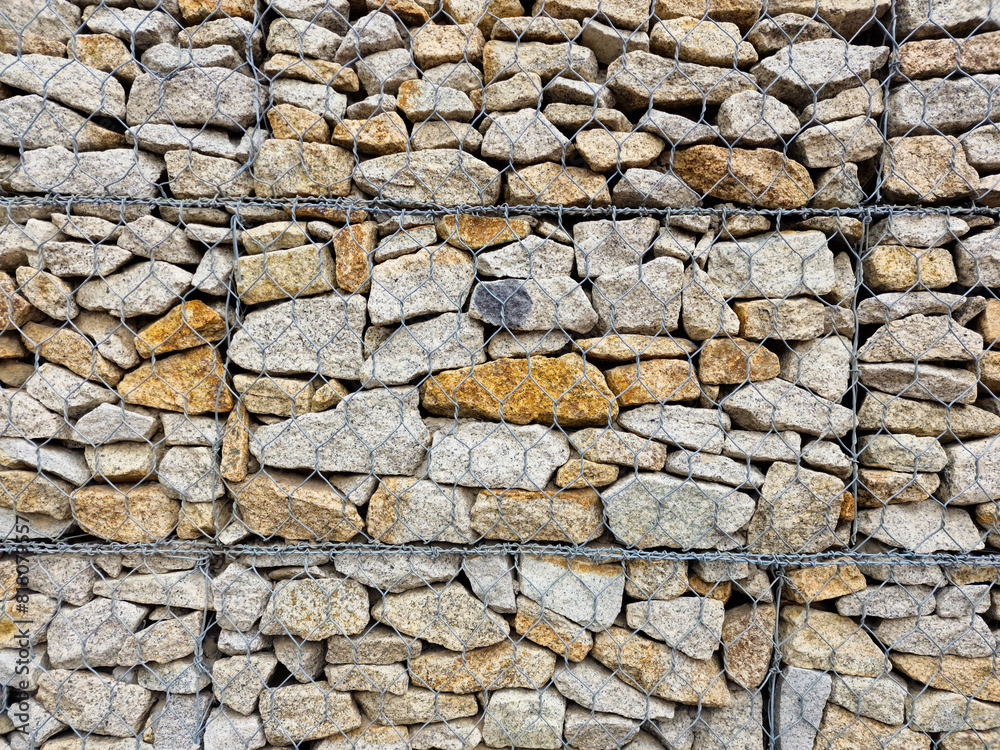 stones in the iron fence used to strengthen the edge of the structure. natural material, decorative wall. landscape design stones in the iron fence used to strengthen the edge of the structure. natural material, decorative wall. landscape design