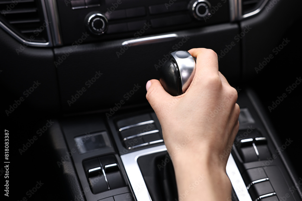 Woman using gear stick while driving her car, closeup Woman using gear stick while driving her car, closeup