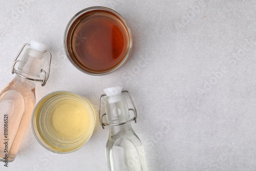 Foto Different types of vinegar on light table, flat lay