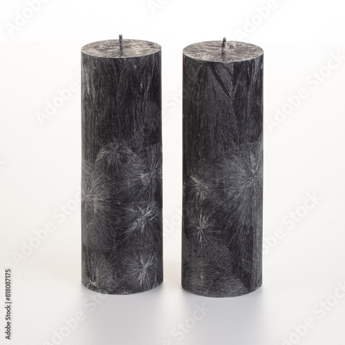 Set of four black palm wax candles with unique ice-like patterns arranged on white background. Concept of stylish handcrafted accessories adding modern touch to home or office decor