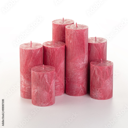 Natural red palm wax pillar candles of varying heights; featuring unique ice pattern texture grouped on white background. Handmade accessories for refreshing interior decor