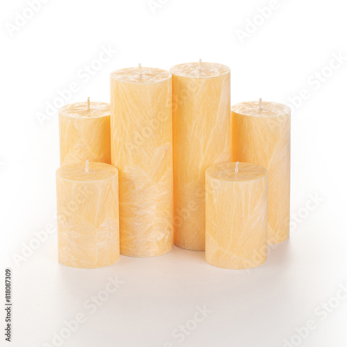 Natural orange palm wax pillar candles of varying heights; featuring unique ice pattern texture grouped on white background. Handmade accessories for refreshing interior decor