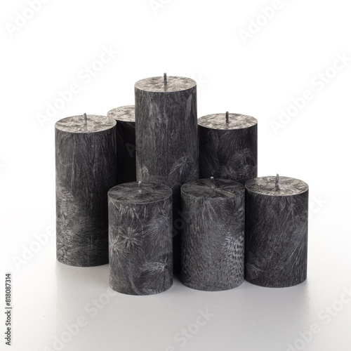 Natural black palm wax pillar candles of varying heights; featuring unique ice pattern texture grouped on white background. Handmade accessories for refreshing interior decor