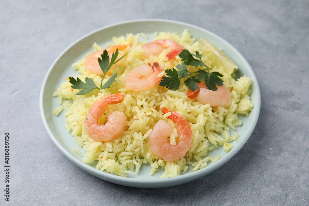 Delicious risotto with shrimps, lime and parsley on light grey table Delicious risotto with shrimps, lime and parsley on light grey table