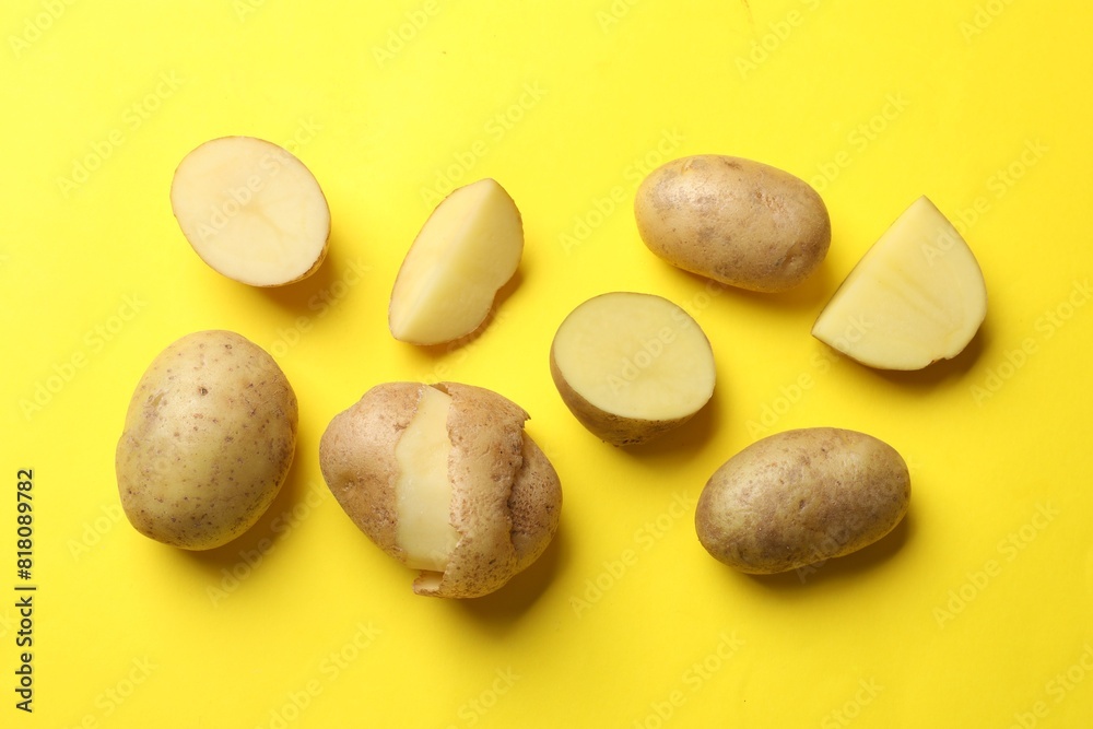 Fresh raw potatoes on yellow background, flat lay Fresh raw potatoes on yellow background, flat lay