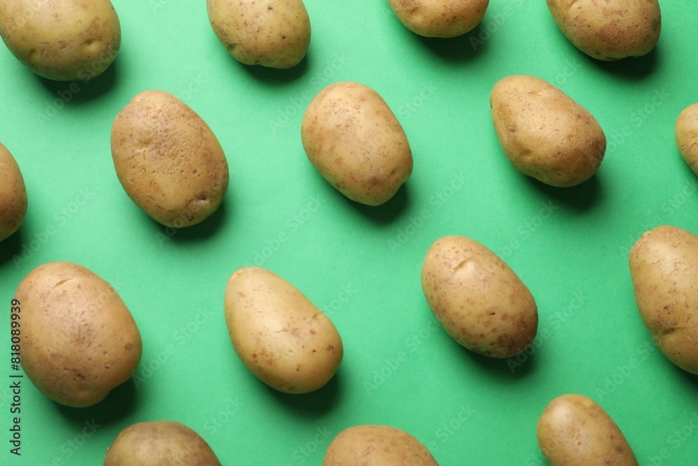 Fresh raw potatoes on green background, flat lay Fresh raw potatoes on green background, flat lay