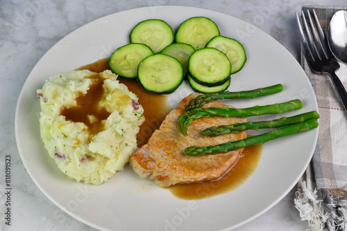 pork chop top wiith asparagus served with mash potatoes photo