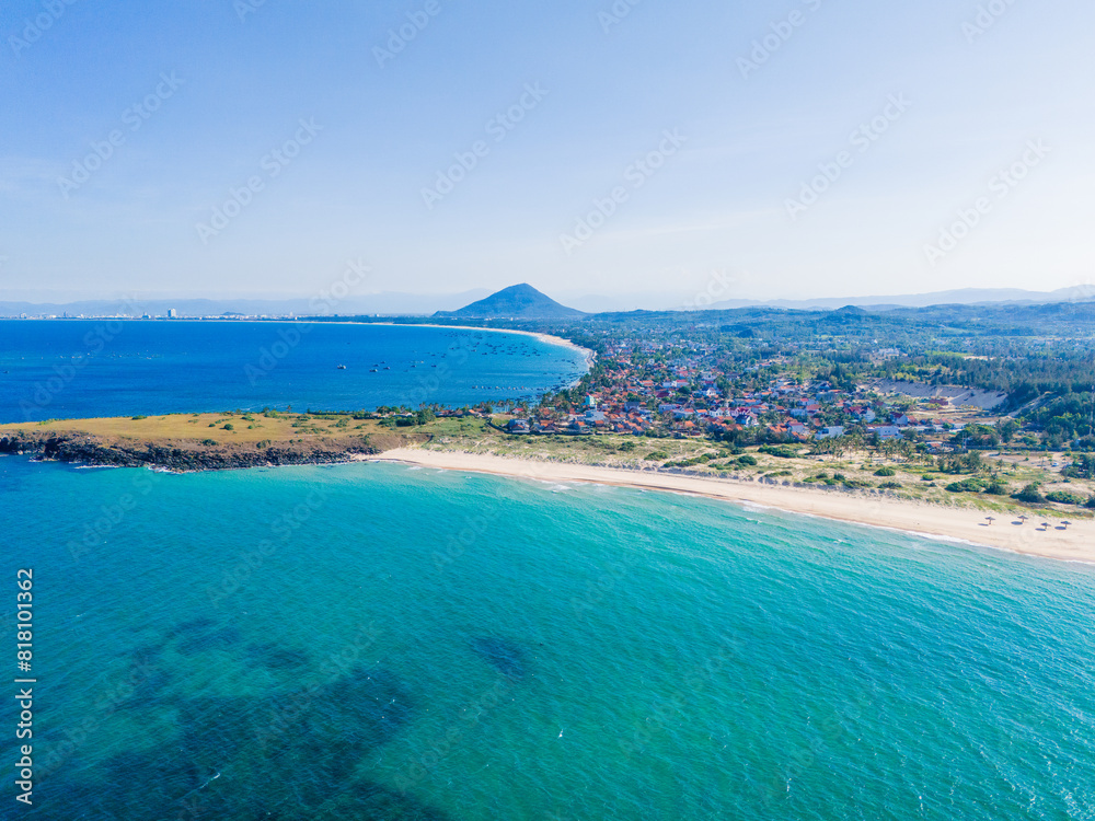 Naklejka premium Aerial view of Bai Xep beach in Phu Yen province, Vietnam. Tropical coast from cliff above. Vietnam travel destination, golden sand beach waving sea rock boulders.