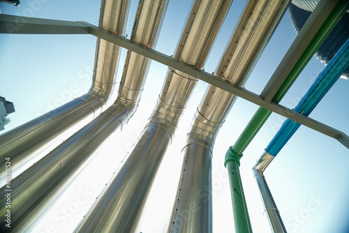 Industrial pipes and structures under clear blue sky, showcasing infrastructure on a construction site