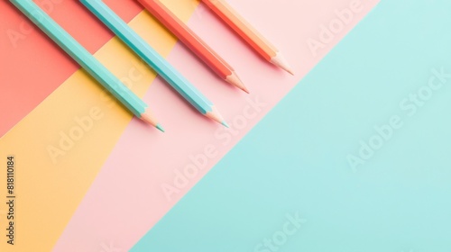 A row of colored pencils on a pink  yellow  and blue background