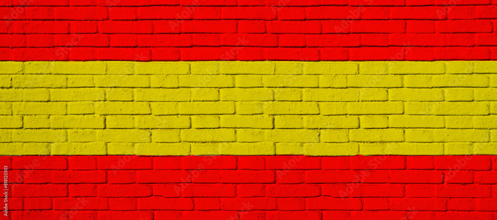 Detail of facade with brick wall painted with the colors of the Spanish flag. Detail of facade with brick wall painted with the colors of the Spanish flag.