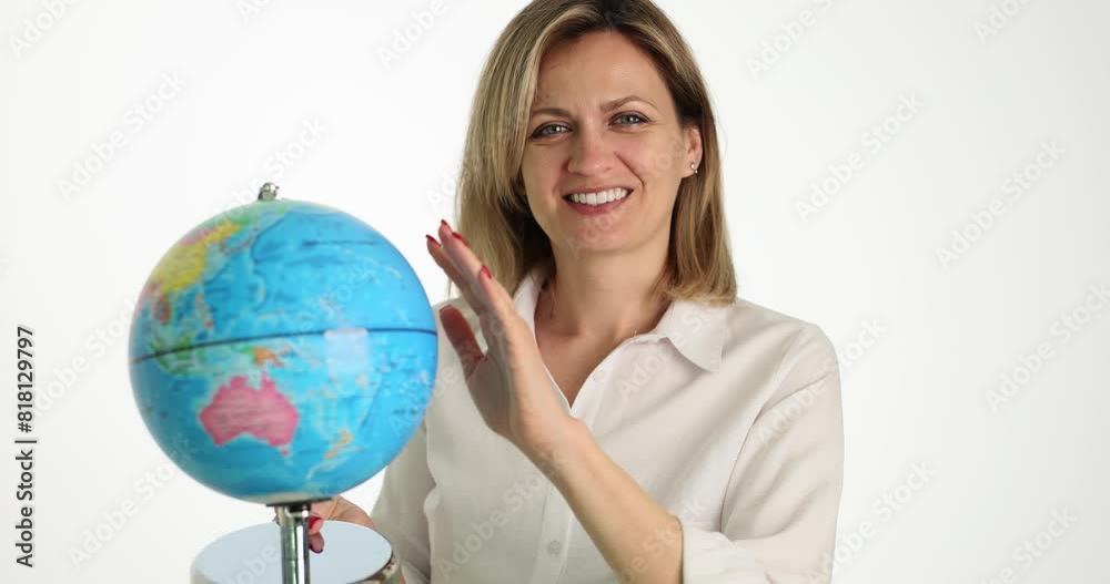 Positive woman spins Earth globe in light premise. Geography female teacher conducts lesson for schoolchildren. Travel agency manager slow motion Positive woman spins Earth globe in light premise. Geography female teacher conducts lesson for schoolchildren. Travel agency manager slow motion