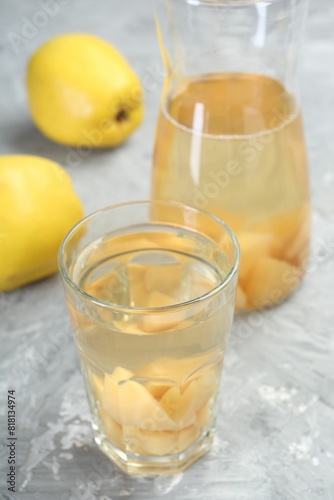 Delicious quince drink and fresh fruits on grey table, closeup