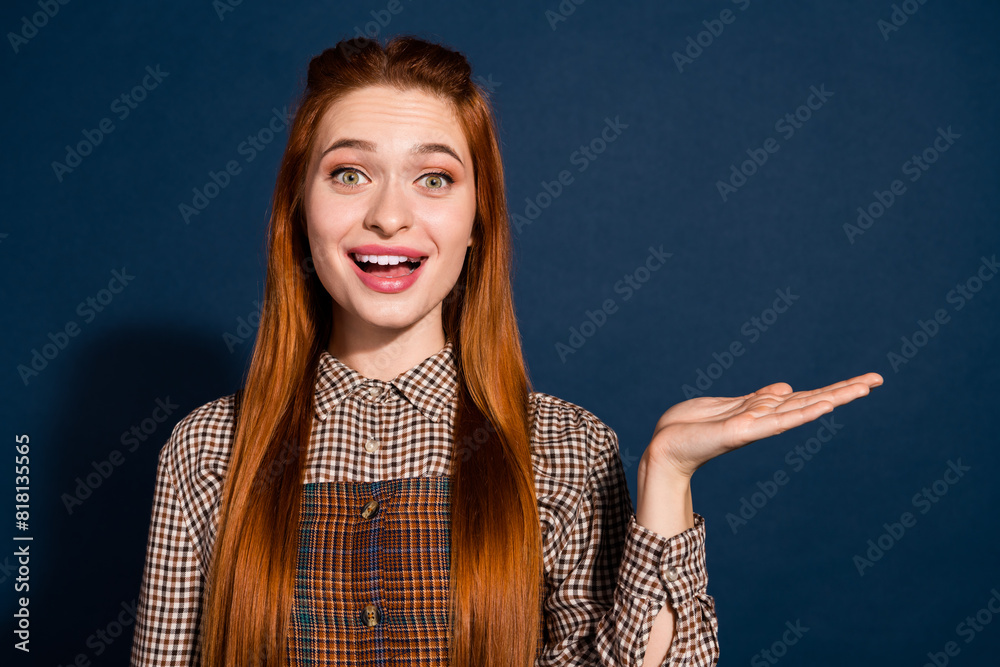 Photo of dreamy excited lady lady dressed plaid outfit holding arm empty space isolated dark blue color background Photo of dreamy excited lady lady dressed plaid outfit holding arm empty space isolated dark blue color background