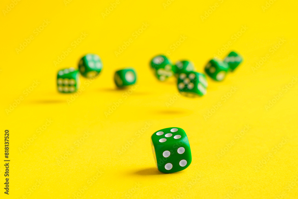Many green game dices falling on yellow background Many green game dices falling on yellow background