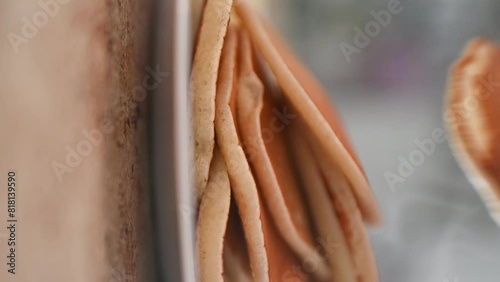 Putting hot pancakes on a plate, close-up photo