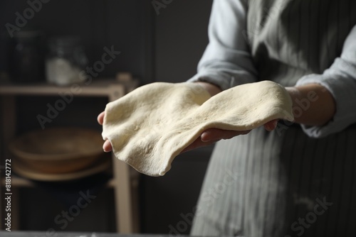 Fotografie Woman tossing pizza dough in kitchen, closeup
