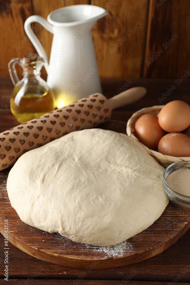 Raw dough, rolling pin and ingredients on wooden table Raw dough, rolling pin and ingredients on wooden table
