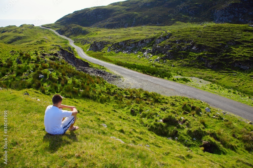 Fototapeta premium Man Sitting Beside Road