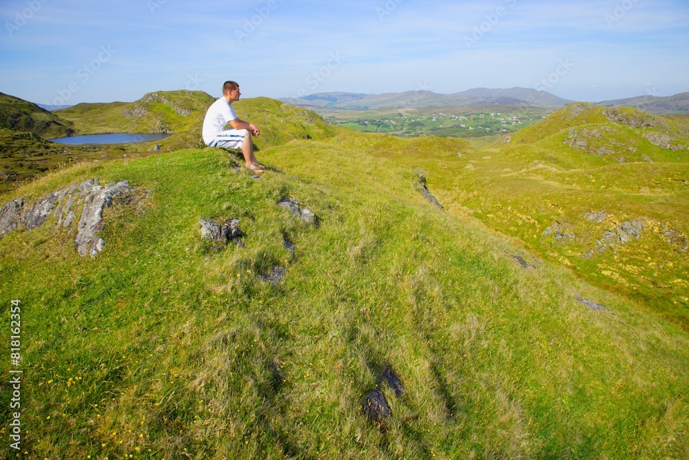 Man Sitting On Top Of A Hill