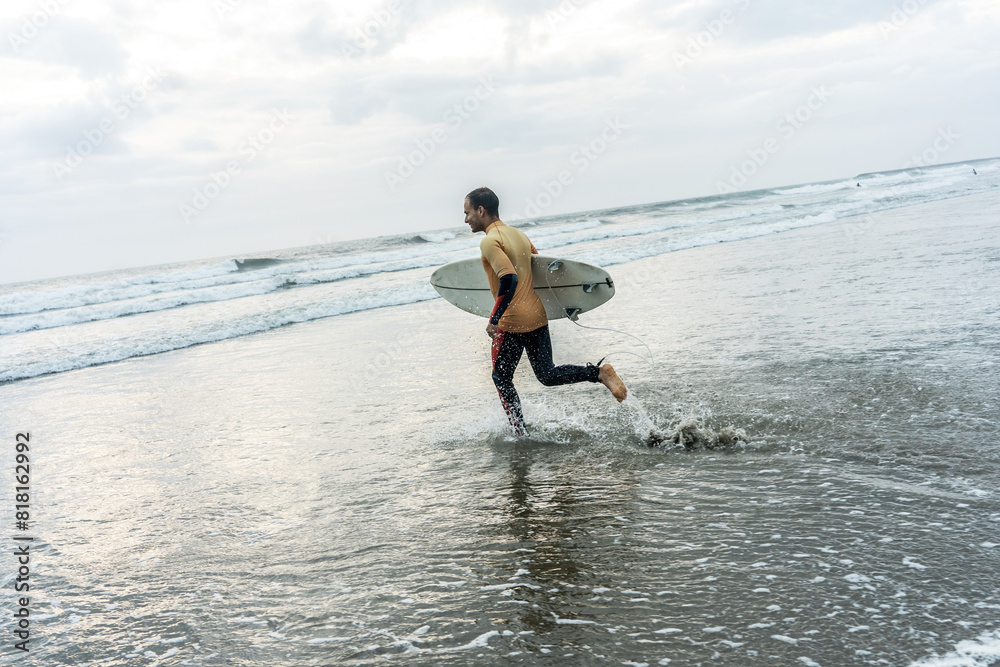 	
Male surfer s walking toward the water. Board in hand, wetsuit on, ready for an exhilarating ride through the waves, creating unforgettable moments on the water.	
