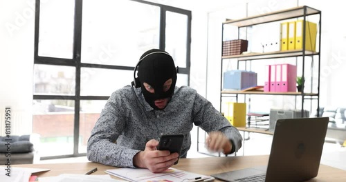 Man with mask and headset talks by videocall with potential victim of online theft. Fraud convinces to invest money in fictive project