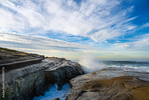  2023-12-31 ROCKY SHORELINE WITH WAVES CRASHING ON THE ROCKS PRODUCING A SPLASH OF WATER WITH A INTENSE BLUE SKY IN LA JOLLA CALIFORNIA BY SAN DIEGO