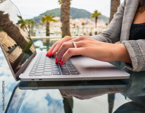 Mano di una donna che digita su una tastiera di laptop con riflessi  photo